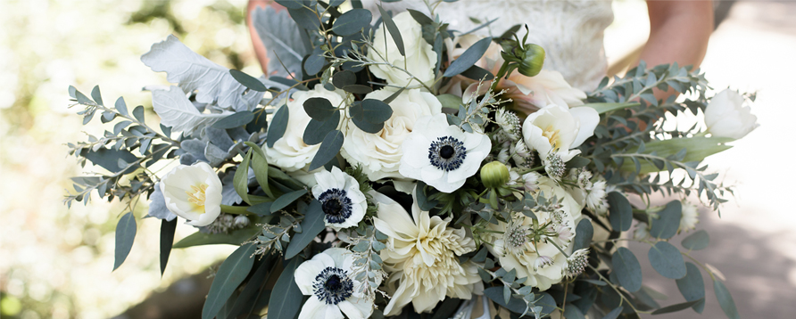 Bouquet of cream and green flowers held by a bride.